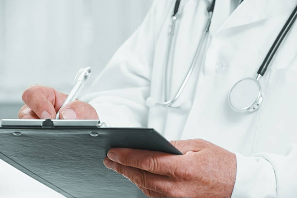 istock Senior doctor writes medical records 520943253