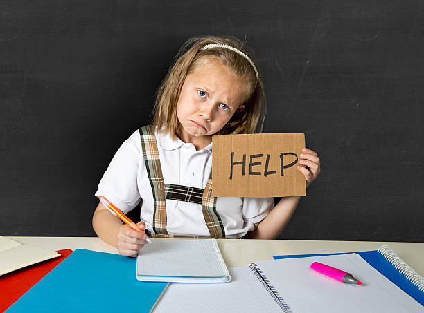 istock junior schoolgirl in stress working doing homework looking bored 520945244