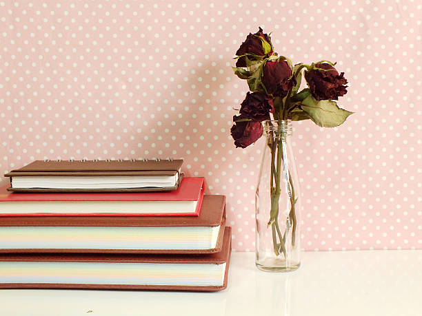 istock dry roses and notebook on pink polka dot background 520945424