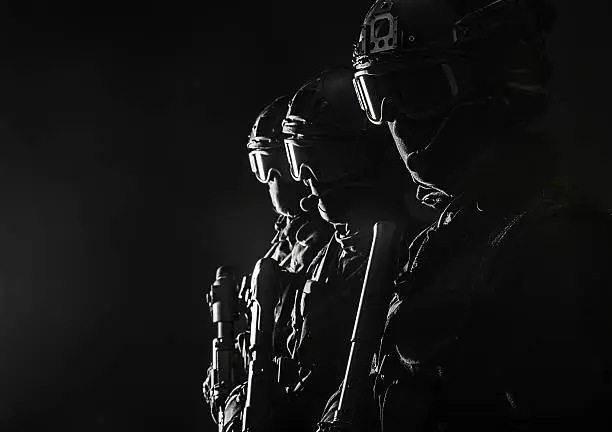 Spec ops police officers SWAT in black uniform and face mask studio shot