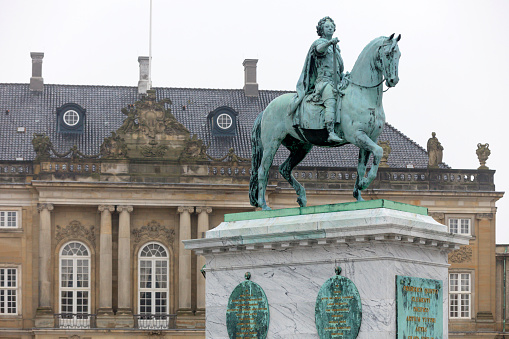 Copenhagen, Denmark - November 15, 2014: equestrian statue of former King Frederick V of Denmark on Amalienborg Square in Copenhagen at dusk.The statue is a work of the French sculptor Jacques Saly and was unveiled in 1771. The Amalienborg Palace consists of four palaces and is the prime residence of the Danish royal family. The palace buildings are placed around the square.