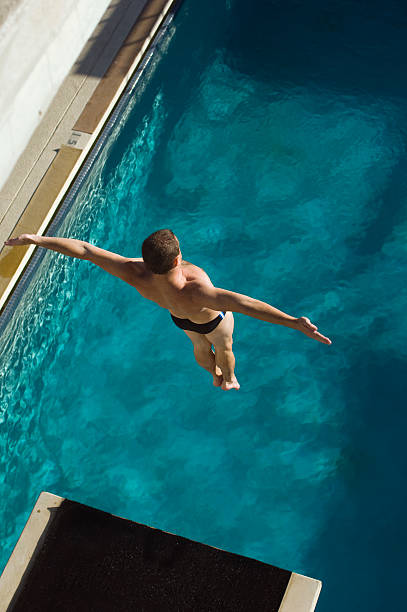 istock Swimmer jumping into swimming pool 520947861