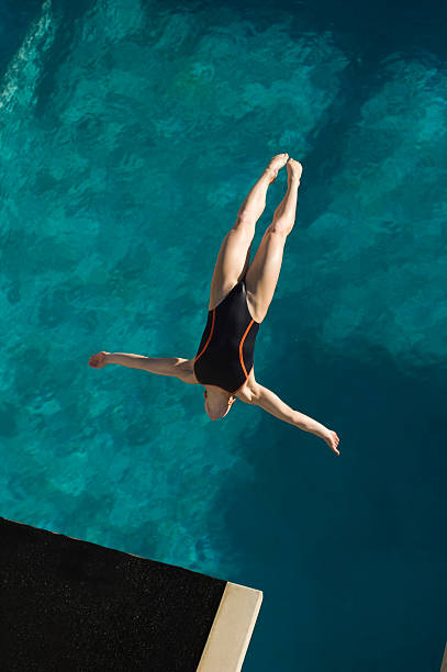 istock Young woman diving into swimming pool 520947863