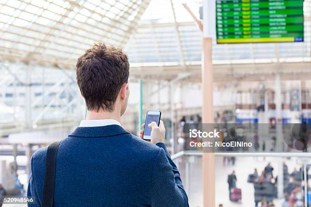 Traveler Sending Text Message On Smartphone In Train Station Stock Photo - Download Image Now