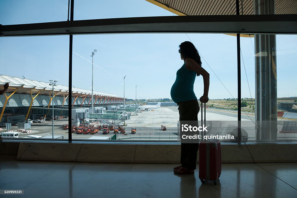 pregnant waiting to fly woman pregnant silhouette waiting to fly in airport hall Pregnant Stock Photo