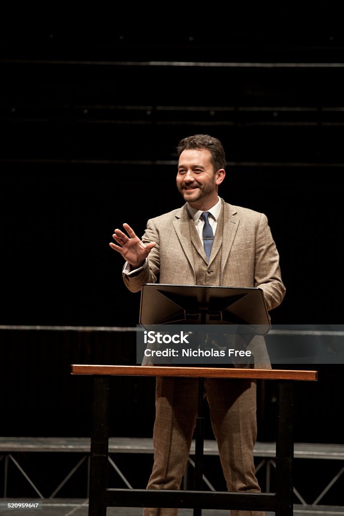 Businessman Presenting to an Audience Bearded and Mustachioed businessman wearing tweed suit talking to a group. Public Speaker Stock Photo