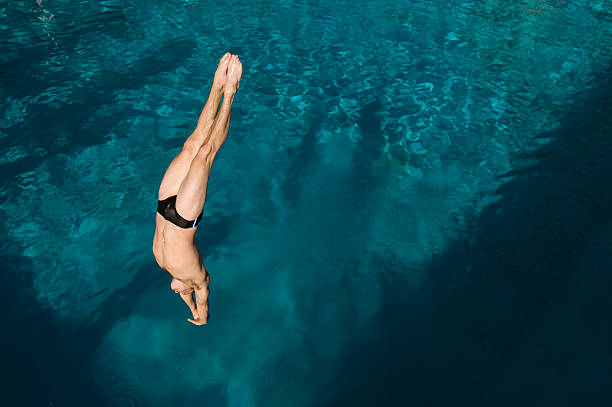 istock Young man diving into swimming pool 520960679