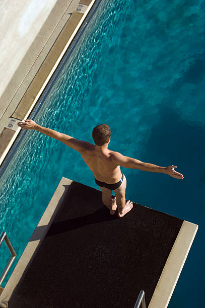 istock Male swimmer standing on diving board 520963609