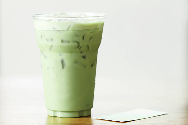 glass of green tea latte on wooden background