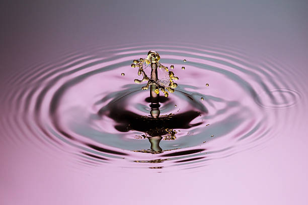 istock Yellow drop mushroom close up ripples pink blue gray surface 520964495
