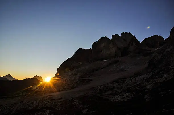 Stunning sunrise photo shot while hiking up Mount Marmolata (Marmolada). Marmolata is the highest mountain in the Dolomites (3343m). The two mountains in the background are Monte Antelao and Monte Pelmo.