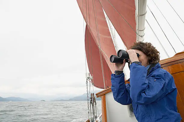 Photo of Woman using binoculars on a sailboat