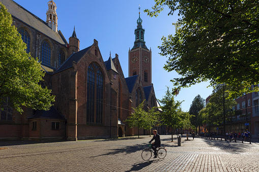 The Hague, Netherlands - July, 21, 2015; cyclists passing the Grote Kerk (Great Church), a protestant church in The Hague. The church is located on Torenstraat and mmembers of the House of Orange-Nassau have been baptised there. The latest are Willem-Alexander of the Netherlands and his daughter Catharina-Amalia, Princess of Orange.