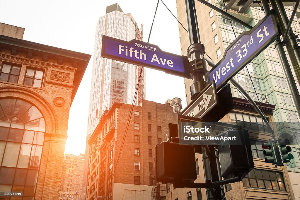 Fifth Ave and West 33rd sign in New York City Street sign of Fifth Ave and West 33rd St at sunset in New York City - Urban concept and road direction in Manhattan downtown - American world famous capital destination on warm dramatic filtered look New York City Stock Photo