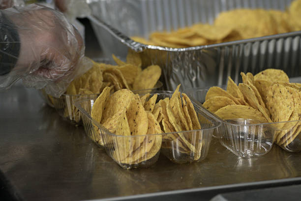 istock Plastic Gloved Hand Preparing Concession Nachos Tortilla Chips Snack Food 520973456