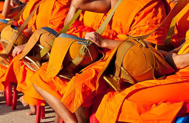 istock Buddhist monks sitting are given food offering from people 520973493