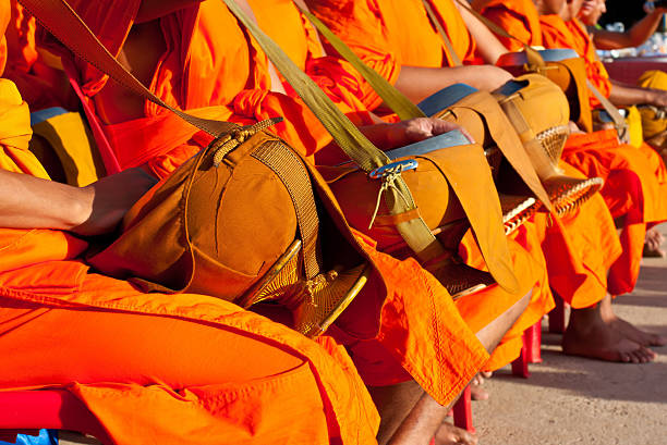 istock Buddhist monks sitting are given food offering from people 520973499