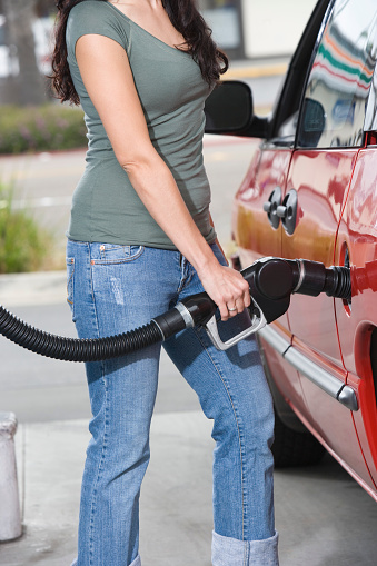 Woman by car with fuel pump