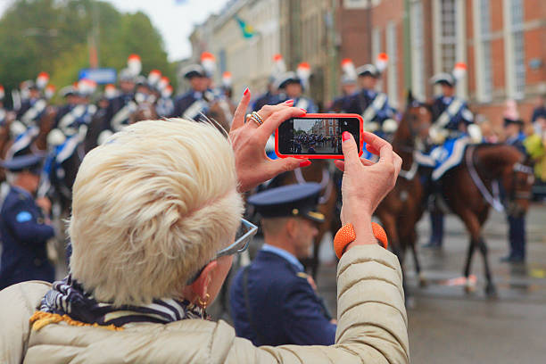 spectator photographing the royal parade on lange voorhout during prinsjesdag - prinsjesdag stockfoto's en -beelden
