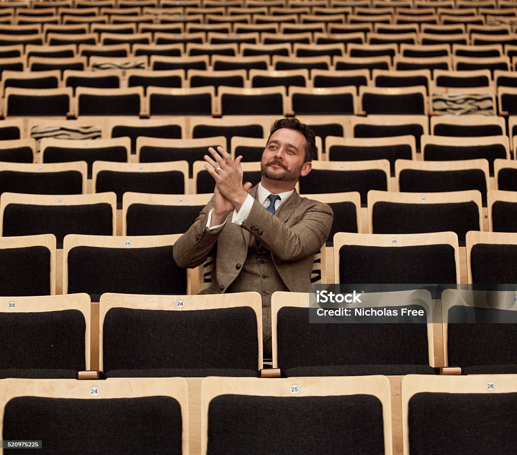 Enjoying the Whole Theatre to Ones Self Enjoying the Show. A businessman has the show to himself Adult Stock Photo
