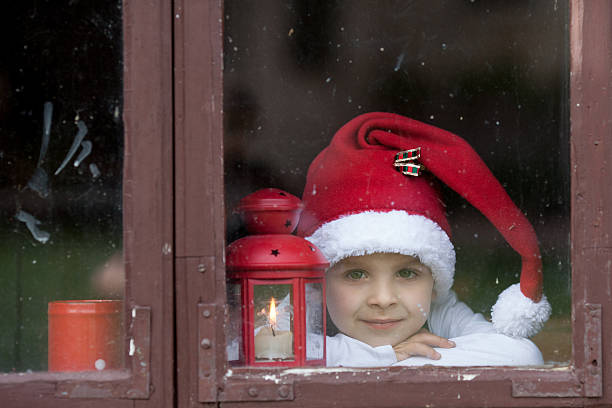 istock Adorable boy, looking through window, waiting for Santa 520978743