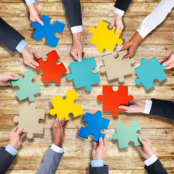 istock Group of Hands Holding Jigsaw Puzzle 520979341