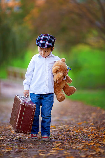 istock Little boy with suitcase and teddy bear 520979373