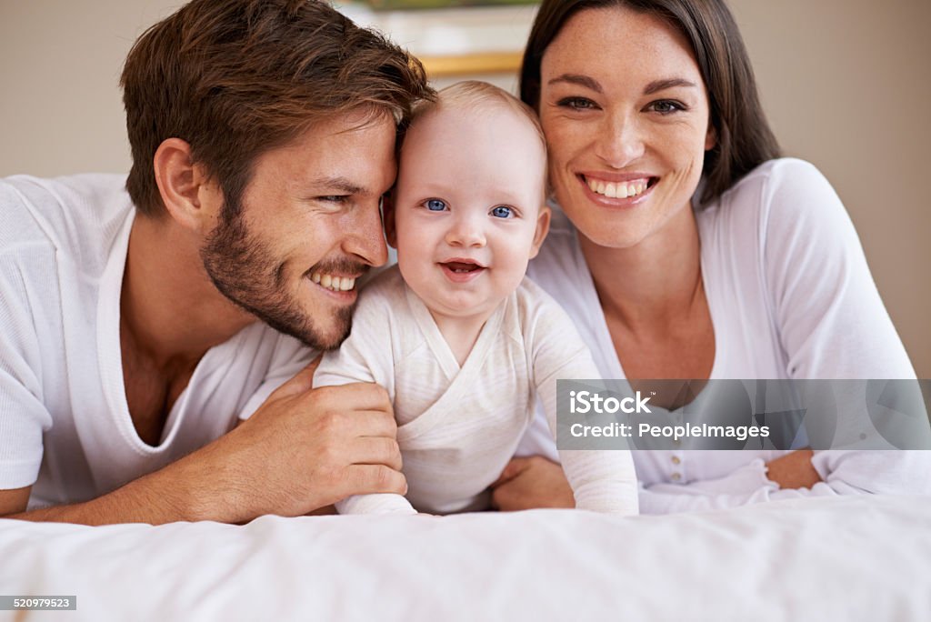 She's our pride and joy Cropped shot of a young couple lying on the bed with their baby girl 6-11 Months Stock Photo