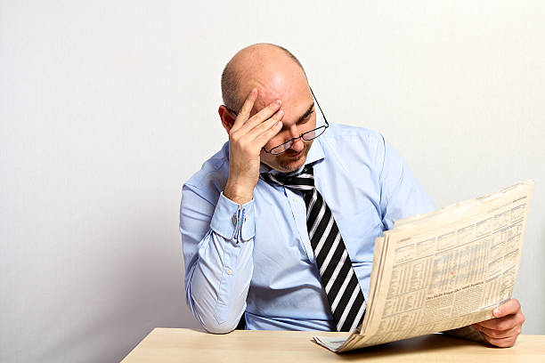 istock Manager studies the financial part of a newspaper. 520980104