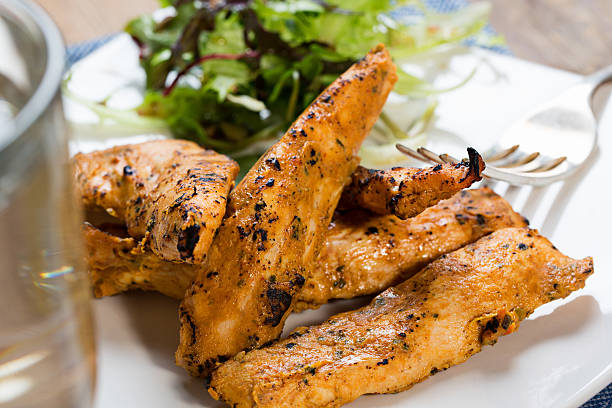 strisce di pollo alla griglia con insalata di contorno - chicken tender foto e immagini stock