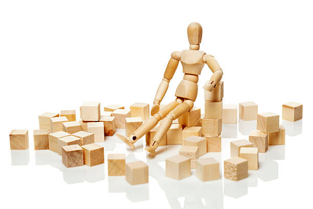 istock Wooden puppet sitting on the wooden blocks 520980790