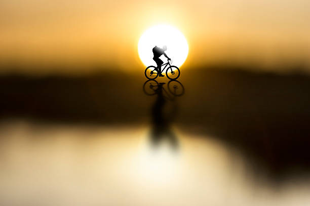 silhouette of cyclist with rucksack on beautiful sunset