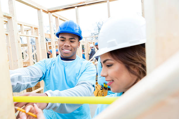 istock Couple measures board as they work on charity home 520983950