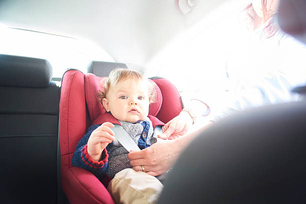 istock Baby boy being fastened in car seat 520984406