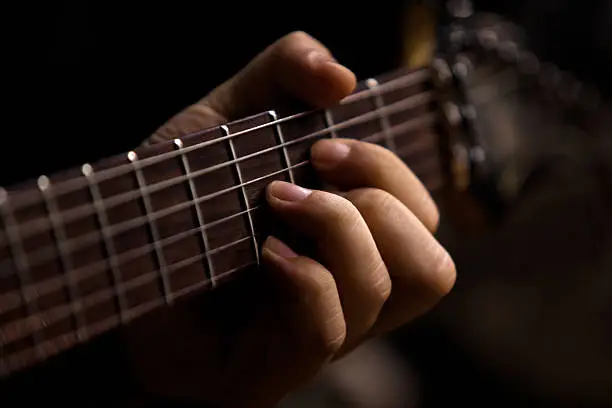 Photo of The hand of man playing guitar