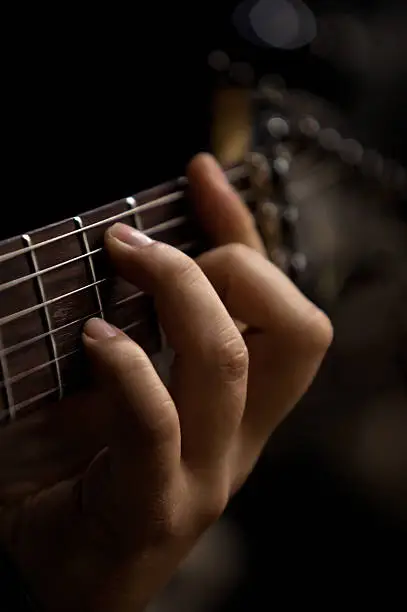 Photo of The hand of man playing guitar