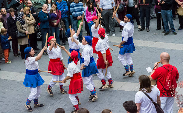 Traditional Catalan dance Olot, Catalonia, Spain - May 1, 2014: Traditional Catalan dance. Olot region of La Garrotxa, in Catalonia. A group of young people dancing a stick dance "Bastons Ball", a traditional Catalan dance, the rhythm of the music, one of the events held to mark the festival of spring. tarde stock pictures, royalty-free photos & images