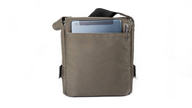 istock Small dark green sling bag and tablet on white background 521001165
