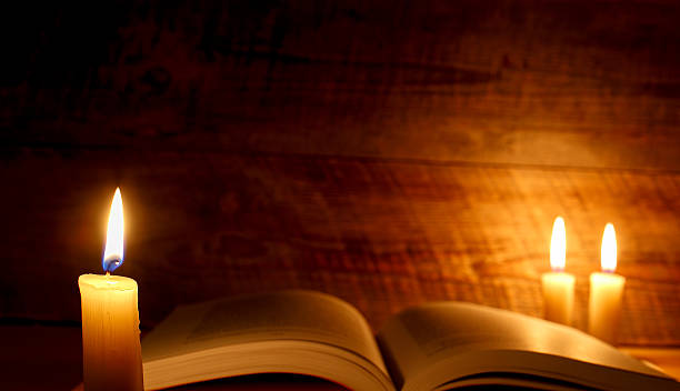 istock concept of knowledge, vintage book with candle 521001562
