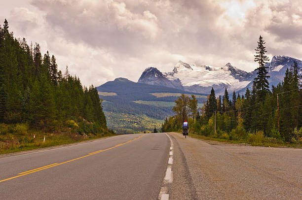 istock Cyclist riding on highway toward glacier 521001618