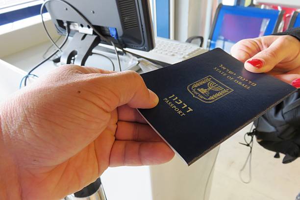 giving passport ------top - customs official examining emigration and immigration document stock-fotos und bilder