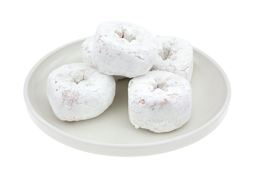 A group of powdered white sugar donuts on a small plate atop a white background.