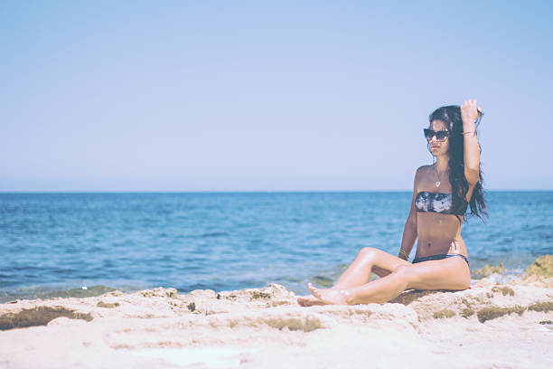 istock Chic brunette sitting on a sea shore 521003446