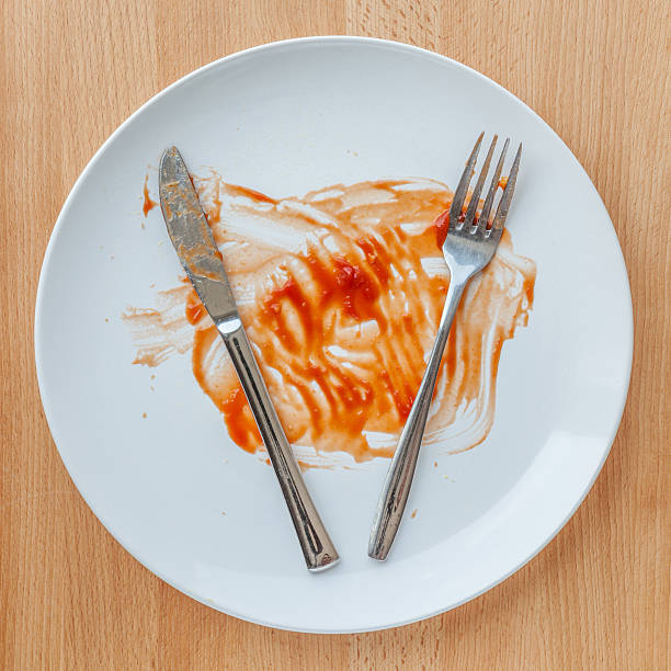 istock Dirty plate with knife and fork smeared with tomato sauce. 521004274