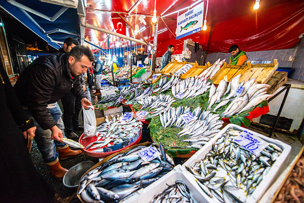 Istanbul, Turkey - October 30, 2014: Fish market in Istanbul. Vendor choosing fish to sell it to customer.