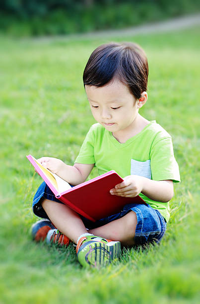 istock The children read a book on the grass 521006507