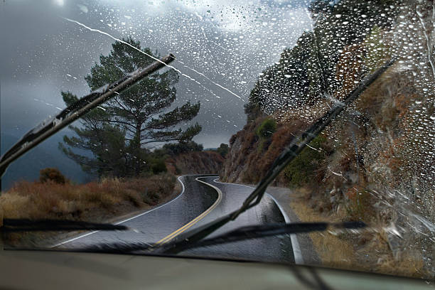 Rainy Mountain Road A vehicle driving through a rainy mountain road with the windshield wipers in motion. windshield wiper photos stock pictures, royalty-free photos & images