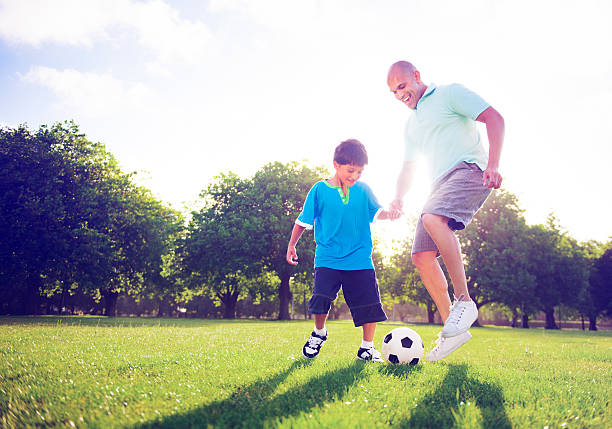 istock Little boy playing soccer with his father Concept 521009078