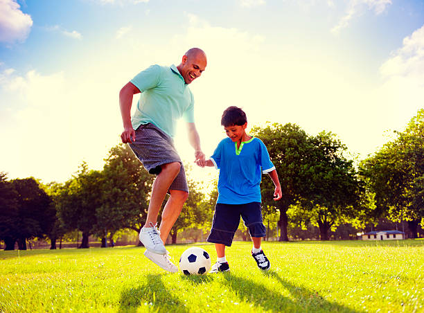 istock Father Son Playing Soccer Park Summer Concept 521009364