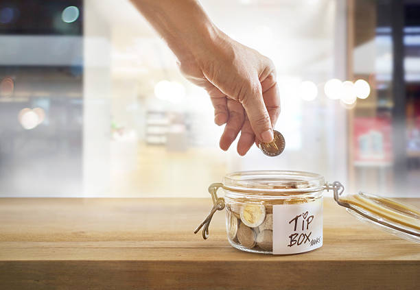 Tip box, coin in the glass bowl in cafe front Tip box, coin in the glass bowl in cafe front of mirror, warm color and soft concept deposit bottle stock pictures, royalty-free photos & images